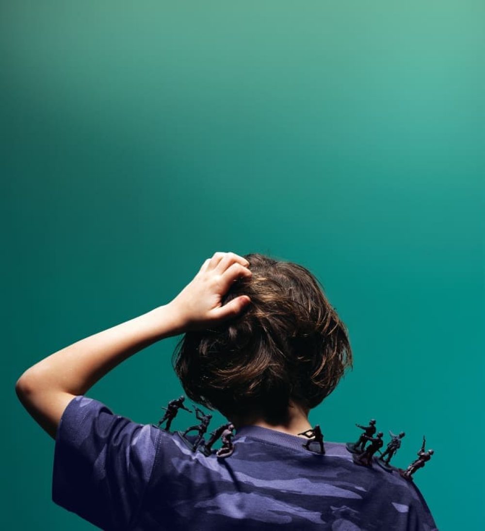 Boy with toy soldiers on shoulder